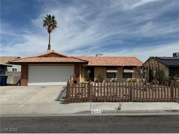 Charming single-story home featuring a well-maintained front yard and a classic red-tiled roof at 325 Greenfield Ln, Las Vegas, NV 89107