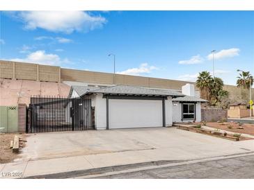 Charming single-story home with a two-car garage and gated drive, set against a bright blue sky at 3911 Chutney St, Las Vegas, NV 89121