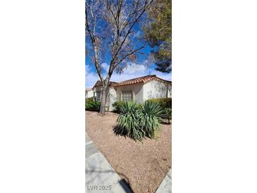 Inviting single-story home with desert landscaping and a terracotta tile roof at 5401 Tassara Way # 102, Las Vegas, NV 89108