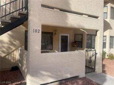 Inviting condo entrance with stairs, security door, and neutral stucco finish at unit 102 at 1112 Observation Dr # 102, Las Vegas, NV 89128