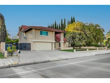 Inviting two-story home featuring a spacious driveway, mature trees and well-manicured front yard at 1546 Georgia Ave, Boulder City, NV 89005