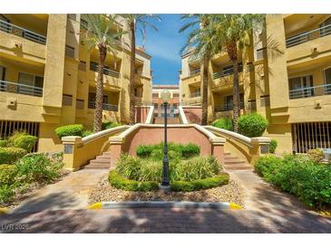 Beautiful courtyard entrance with palm trees and well-maintained landscaping leading to condo buildings at 230 E Flamingo Rd # 115, Las Vegas, NV 89169