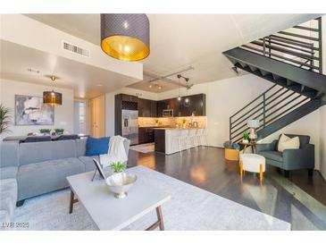 Bright and airy living room featuring modern furnishings, a stylish staircase, and an open floor plan at 353 E Bonneville Ave # 746, Las Vegas, NV 89101