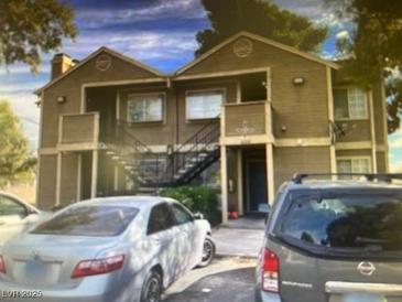 A two-story apartment building with stairs and covered walkways showing neutral paint and parking at 4696 Krissylouise Way, Las Vegas, NV 89121