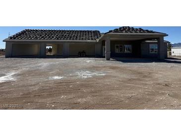 Sprawling new construction property featuring an attached three car garage and covered entry at 1351 Huckleberry St, Pahrump, NV 89048