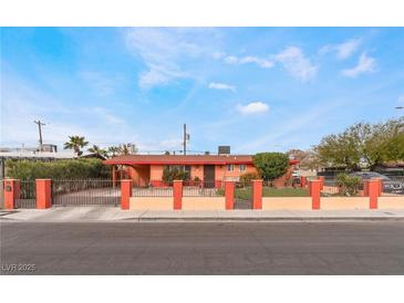 Charming single-story home featuring a secure metal gate and orange exterior at 147 Cervantes St, Las Vegas, NV 89101