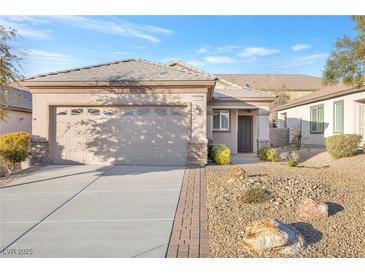 Charming single-story home featuring a two-car garage and a meticulously landscaped front yard with desert landscaping at 2444 Gamma Ray Pl, Henderson, NV 89044