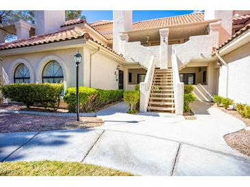 Inviting condominium exterior featuring well-maintained landscaping and a staircase leading to upper units at 2611 S Durango Dr # 102, Las Vegas, NV 89117