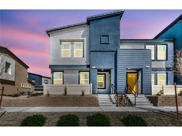 Inviting two-story home showcasing a modern design, beautiful landscaping, and a vibrant yellow front door at 3725 Celesta Vista Ave, Henderson, NV 89044