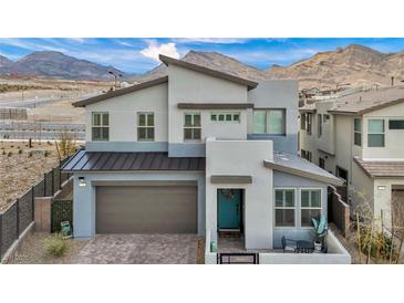 Contemporary two-story home boasts a modern design, mountain views, and a teal-colored front door at 705 Carlon Hills Ave, Las Vegas, NV 89138