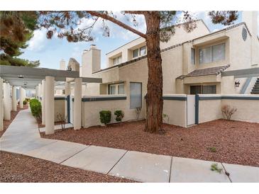 Inviting townhome featuring a charming exterior, tree, and well-kept landscaping at , Las Vegas, NV 89117
