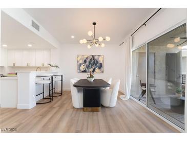 Bright dining room features a modern light fixture and sliding glass doors to the patio at 10809 Garden Mist Dr # 2072, Las Vegas, NV 89135