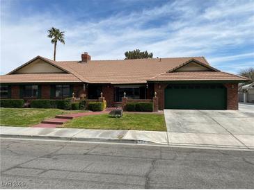 Charming single-story home with a well-manicured lawn, brick accents, and a two-car garage at 1104 Oak Tree Ln, Las Vegas, NV 89108
