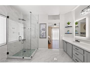 Modern bathroom featuring a glass shower, marble floors, and neutral gray tones at 1405 Bugle Boy Dr, Henderson, NV 89014