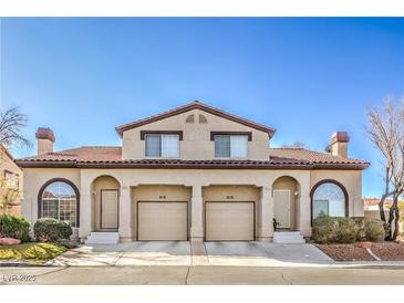 Inviting two-story townhome featuring dual garages and landscaped front yards under a bright blue sky at 2609 Orchard Meadows Ave, Henderson, NV 89074