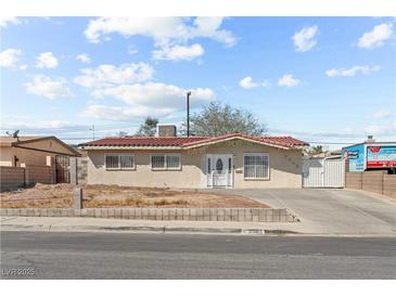 Charming single-story home featuring a red tile roof, secure window bars, and a well-maintained concrete driveway at 2963 Greendale St, Las Vegas, NV 89121