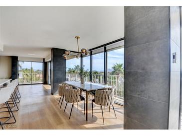Bright dining room with balcony access offers stunning views and a modern chandelier at 3111 Bel Air Dr # 5F, Las Vegas, NV 89109