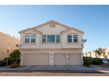 Three car garage exterior view of condo, each with its own entrance and front window at 8628 Tomnitz Ave # 101, Las Vegas, NV 89178
