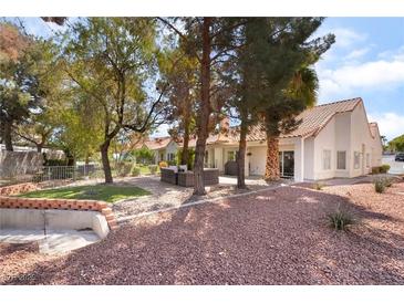 A backyard with a patio set, rock landscaping and various trees at 2246 Cassatt Dr, Henderson, NV 89074