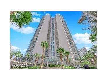 Stunning high-rise exterior with palm trees, lush landscaping, and a grand entrance under a clear blue sky at 322 Karen Ave # 2003, Las Vegas, NV 89109