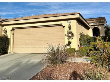 Exterior of home showcasing the two-car garage and manicured front yard, including desert landscaping and healthy shrubs at 4534 Regalo Bello St, Las Vegas, NV 89135