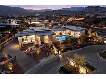 Stunning aerial view of a modern home featuring a pool, landscaped grounds, and mountain views at 63 Midnight Sky Dr, Las Vegas, NV 89135