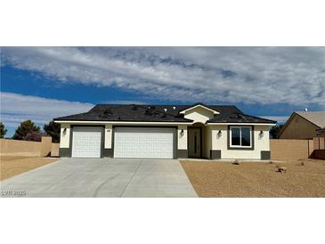 Charming single-story home with a three-car garage, neutral paint, and desert landscaping at 6840 Stubblefield Dr, Pahrump, NV 89061