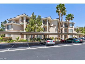 Attractive condominium complex with covered parking, mature landscaping, and palm trees on a beautiful sunny day at 7155 S Durango Dr # 303, Las Vegas, NV 89113