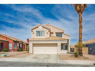 Two-story home featuring a two-car garage, desert landscaping and a beige stucco exterior at 938 Carnival Ave, Las Vegas, NV 89123