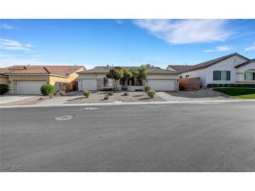 Charming single-story home with a three-car garage, desert landscaping, and stone accents at 9485 Parkmoor Ave, Las Vegas, NV 89149