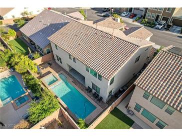 An elevated shot showcasing a backyard oasis featuring a pool, spa, and outdoor seating area at 1004 Bluebird Ridge Ct, North Las Vegas, NV 89084