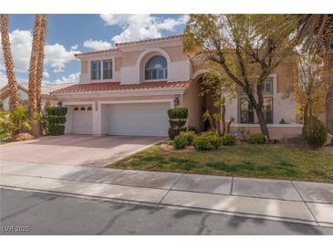 Charming two-story home featuring a three-car garage, landscaped yard, and a red tile roof at 21 Ocean Harbour Ln, Las Vegas, NV 89148