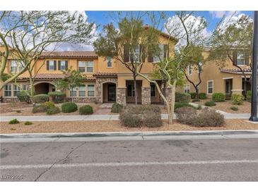 Charming townhome featuring desert landscaping, stone accents, and neutral color scheme at 2376 Via Firenze, Henderson, NV 89044