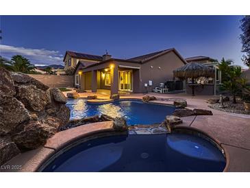 Beautiful backyard pool with hot tub, rock features, and tiki bar create an outdoor oasis at 2764 Kilwinning Dr, Henderson, NV 89044