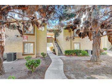 Inviting condominium complex with manicured landscaping and mature trees surrounding the building at 7300 Pirates Cove Rd # 2087, Las Vegas, NV 89145