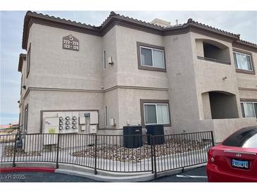 Low angle of the two story condo featuring multiple windows and exterior utility components and a red car in the parking lot at 8725 W Flamingo Rd # 226, Las Vegas, NV 89147
