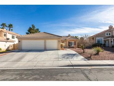Charming single-story home featuring a two-car garage, tile roof, and desert landscaping at 455 Paulson Dr, Las Vegas, NV 89123