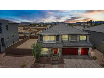 Elegant two-story home with a three-car garage and mountain views at sunset at 7255 Bold Rock Ave, Las Vegas, NV 89113
