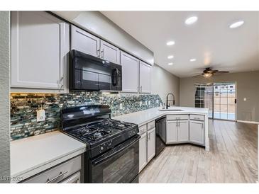 Modern kitchen featuring stainless steel appliances, gray cabinets, and beautiful backsplash at 2836 Floral Peak Dr, Henderson, NV 89074