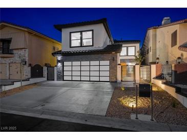 Stunning two-story home with a modern garage door and well-maintained landscaping at 2861 Queens Courtyard Dr, Las Vegas, NV 89109