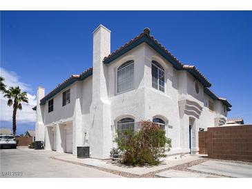 Charming two-story stucco home with attached garage, chimney, and beautiful curb appeal against a clear blue sky at 8160 Autumn Star Ave, Las Vegas, NV 89145