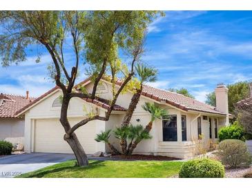 Charming one-story home featuring a two-car garage, lush landscaping, and a beautiful terracotta tile roof at 8582 Manalang Rd, Las Vegas, NV 89123