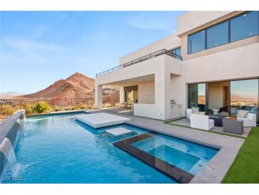Stunning backyard pool and spa with mountain views, plus an outdoor seating area and built-in grill for entertaining at 10 Sand Star Ln, Henderson, NV 89011