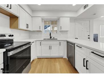 Updated kitchen with stainless steel appliances, white cabinets, and quartz countertops at 2725 S Nellis Blvd # 1033, Las Vegas, NV 89121