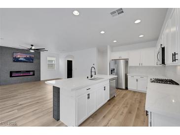 Bright, open kitchen features a large island, stainless steel appliances, and modern white cabinetry at 8043 Tank Loop St, Las Vegas, NV 89166