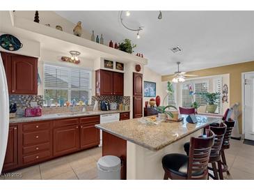 Bright eat-in kitchen features granite counters, stainless appliances, and wood cabinets at 8217 Ashkum Ave, Las Vegas, NV 89149