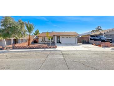 Charming single-story home featuring a well-maintained front yard and attached two-car garage at 1120 Mariposa Way, Boulder City, NV 89005