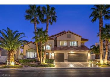 Beautiful two-story home with a three-car garage and palm trees lining the front at twilight at 2232 Barchetta Dr, Las Vegas, NV 89134