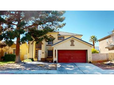 Charming two-story home featuring a red two-car garage door and a well-maintained front yard at 5517 Rose Thicket St, Las Vegas, NV 89130