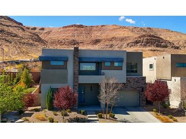 Striking modern two-story home boasting a desert landscape, neutral tones, and a mountain backdrop at 6197 Jewel Vista St, Las Vegas, NV 89135